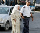 شرطي مرور يساعد مسنة بعبور الشارع في مدينة جنين