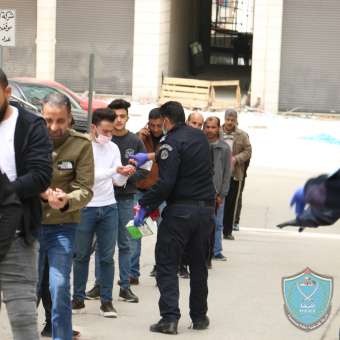 الشرطة تنظم حركة المواطنين على الصراف الآلي وتوزع المعقمات علهيم في نابلس