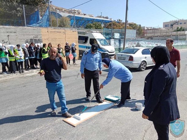 الشرطة تشارك في فعالية رسم خطوط المشاة أمام إحدى المدارس في الخليل