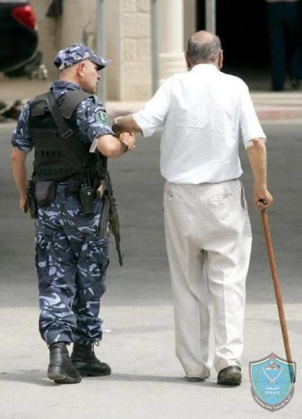 شرطي يساعد مسن بعبور الطريق