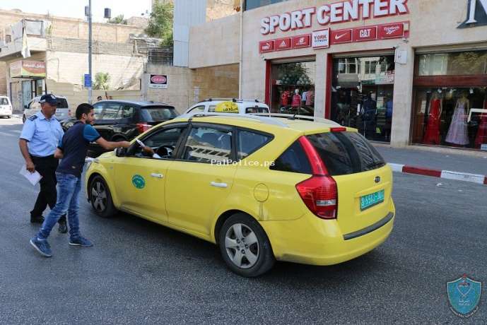 مجموعة من المتطوعين يساندون الشرطة في حملتها بنشر التوعية المرورية في الخليل